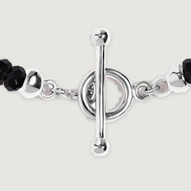 A close view shows the silver toggle bar, circular clasp, small connecting links, and adjacent faceted black beads.