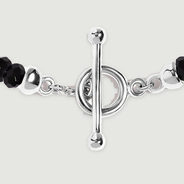 A close view shows the silver toggle bar, circular clasp, small connecting links, and adjacent faceted black beads.