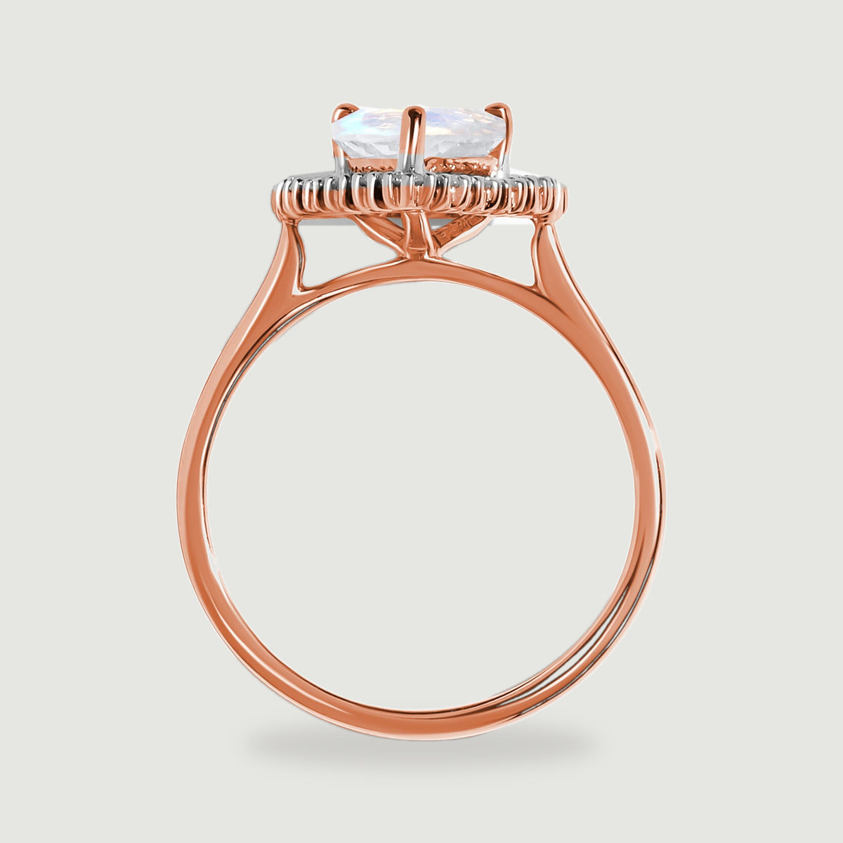 The side of the rose gold ring shows a raised moonstone setting, diamond halo and slender circular band.