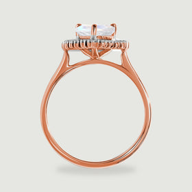 The side of the rose gold ring shows a raised moonstone setting, diamond halo and slender circular band.
