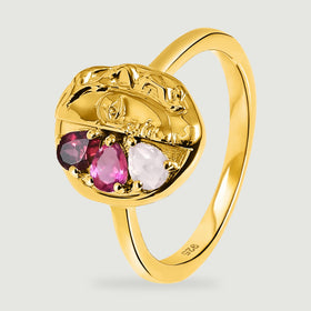 An angled yellow gold ring reveals its curved band and three pear-shaped stones beneath the sculpted face.