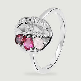 The silver ring is shown at an angle with its curved band, polished face relief and three colored stones visible.