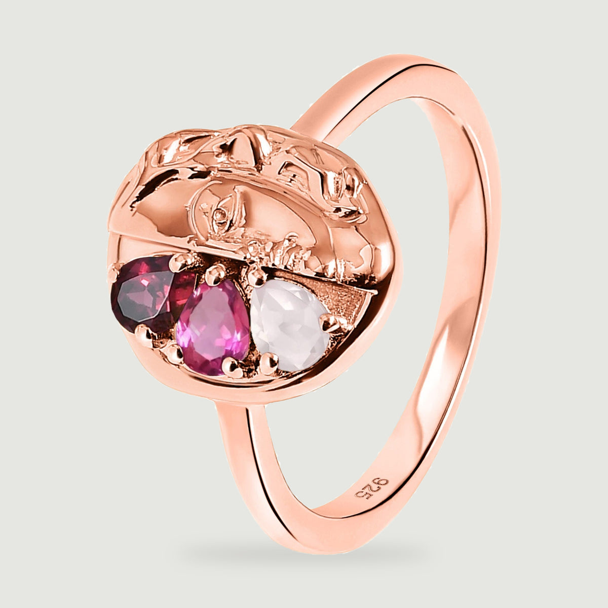 A tilted rose gold ring displays the raised face detail, stone prongs and the small 925 stamp inside the band.