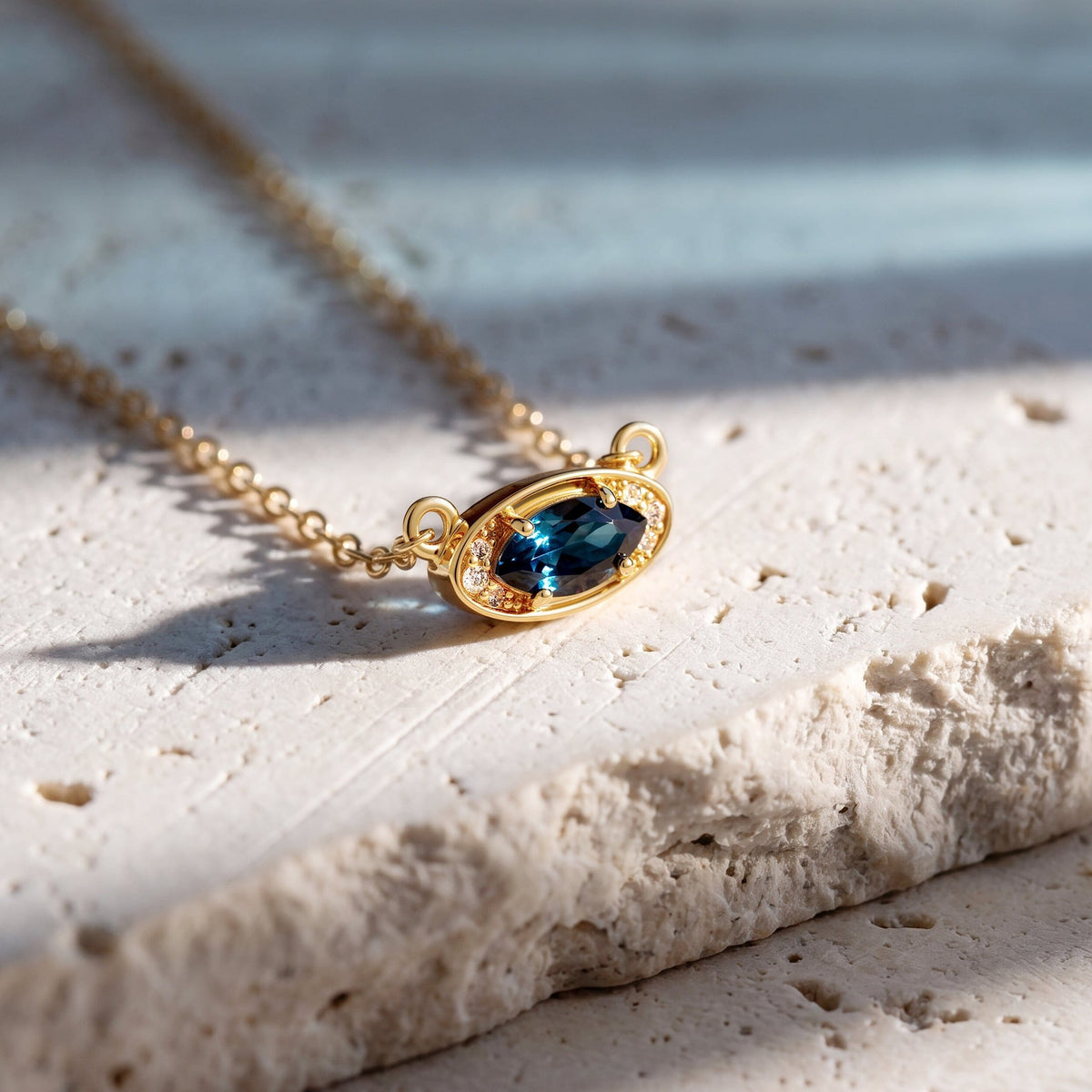 Blue topaz pendant on a textured stone surface