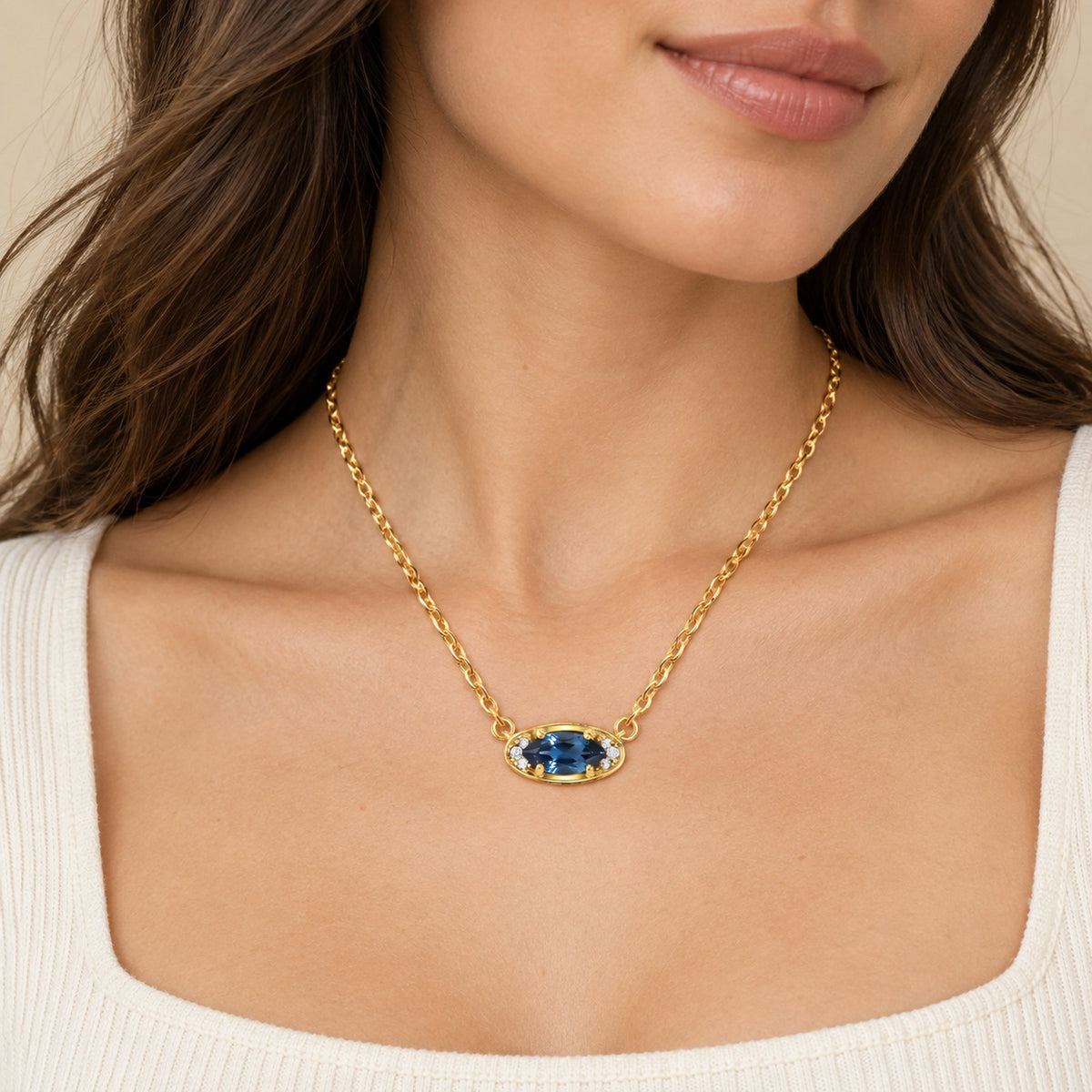 Blue topaz evil eye necklace on a white square-neck top