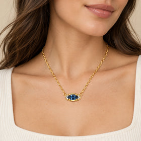 Blue topaz evil eye necklace on a white square-neck top