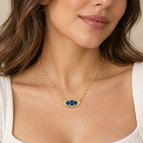 Blue topaz evil eye pendant necklace worn in soft daylight