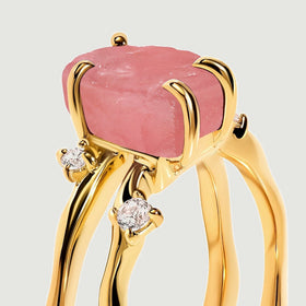 A side close-up shows the rough pink stone above two yellow gold bands with clear accent stones.