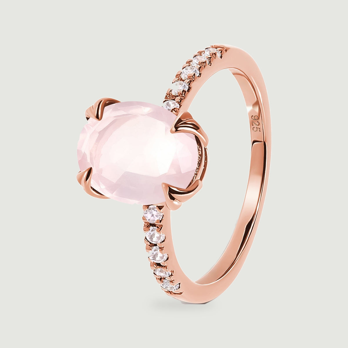 The side of a rose gold vermeil ring shows sculpted prongs around a pale pink faceted stone.