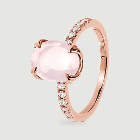The side of a rose gold vermeil ring shows sculpted prongs around a pale pink faceted stone.