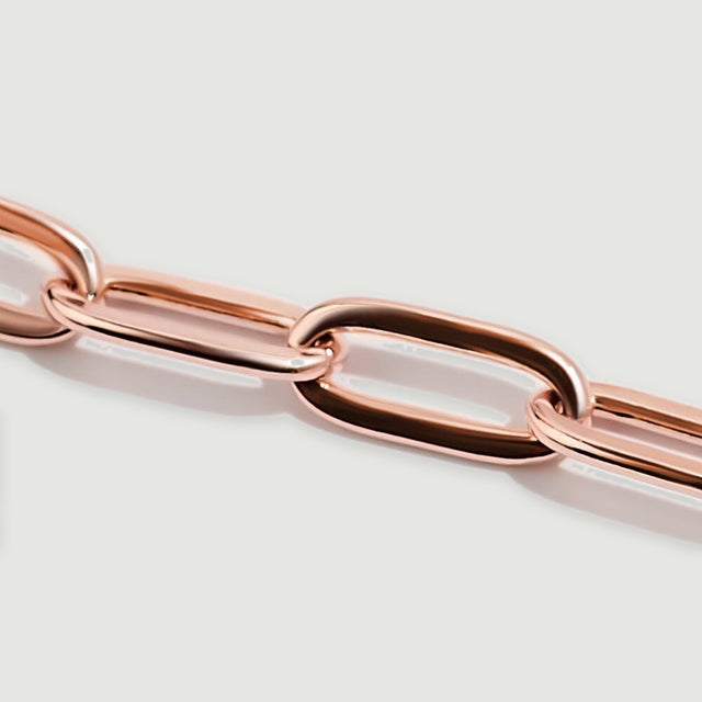 A close view shows the smooth surfaces and interwoven elongated rose gold links.