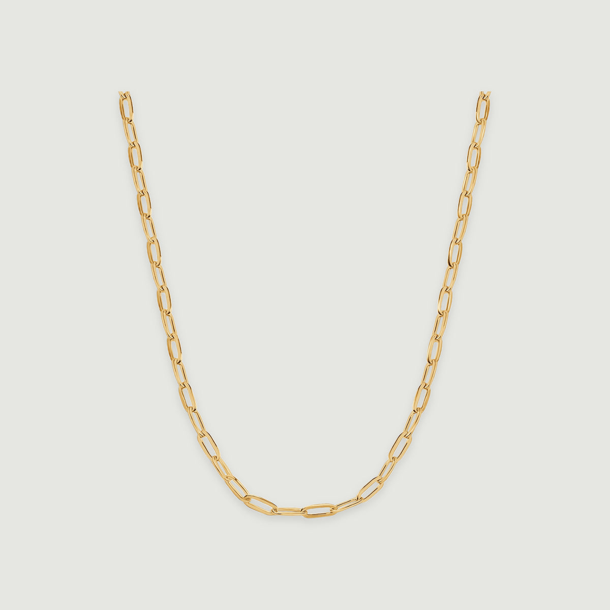 A yellow gold chain necklace forms a smooth U with elongated open links on a light gray background.