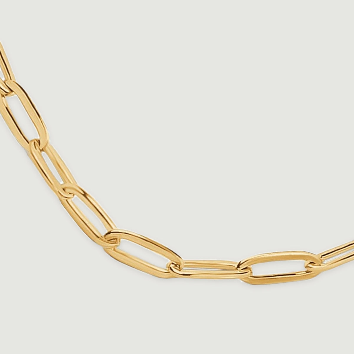 A close view shows elongated yellow gold links curving across the bottom of the chain.