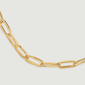 A close view shows elongated yellow gold links curving across the bottom of the chain.