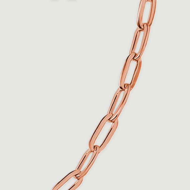 Rose gold chain links show rounded corners and bright reflections in a diagonal close view.