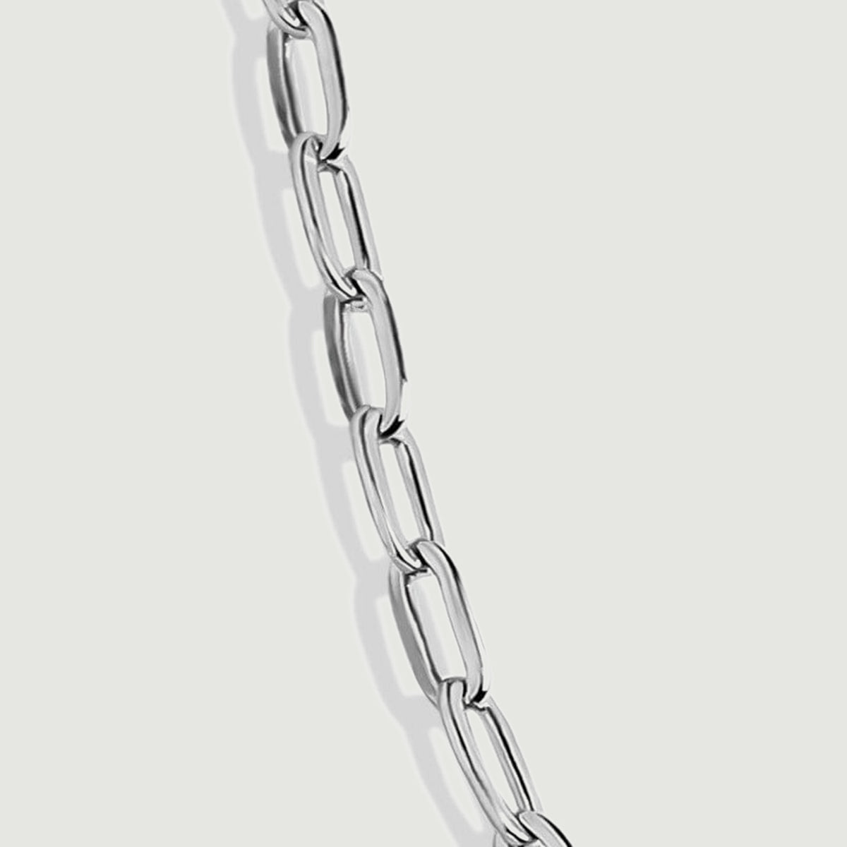 A magnified silver chain section reveals open link centers and polished reflective edges.