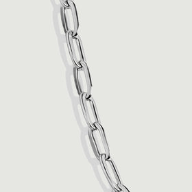 A magnified silver chain section reveals open link centers and polished reflective edges.
