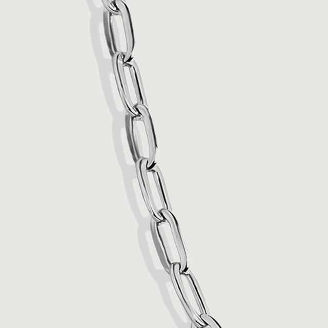 A magnified silver chain section reveals open link centers and polished reflective edges.