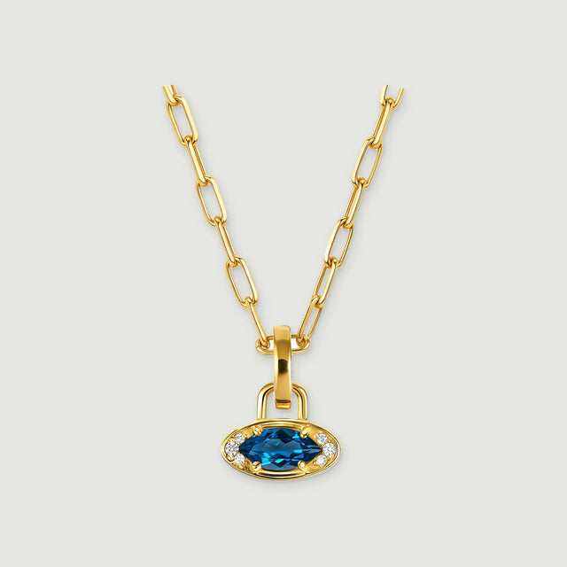 A yellow gold-tone chain supports a blue oval pendant with small clear stones on either side.