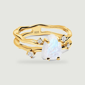 A yellow gold ring surrounds a pale blue-white moonstone with four clear stone accents.
