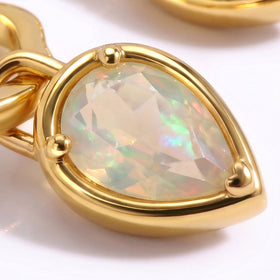 A close view shows a faceted pear-shaped opal held by three yellow gold prongs and a polished rim.