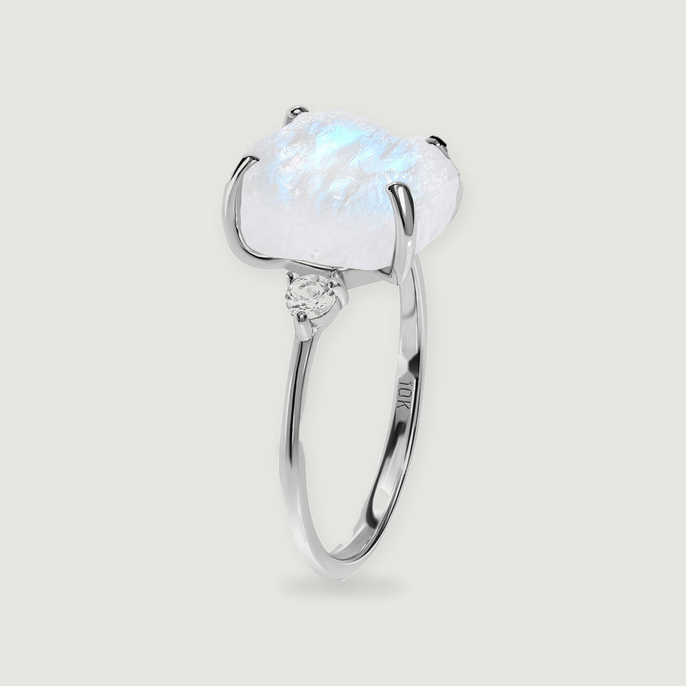 The white gold ring stands upright, revealing the raised moonstone setting and slim curved band.