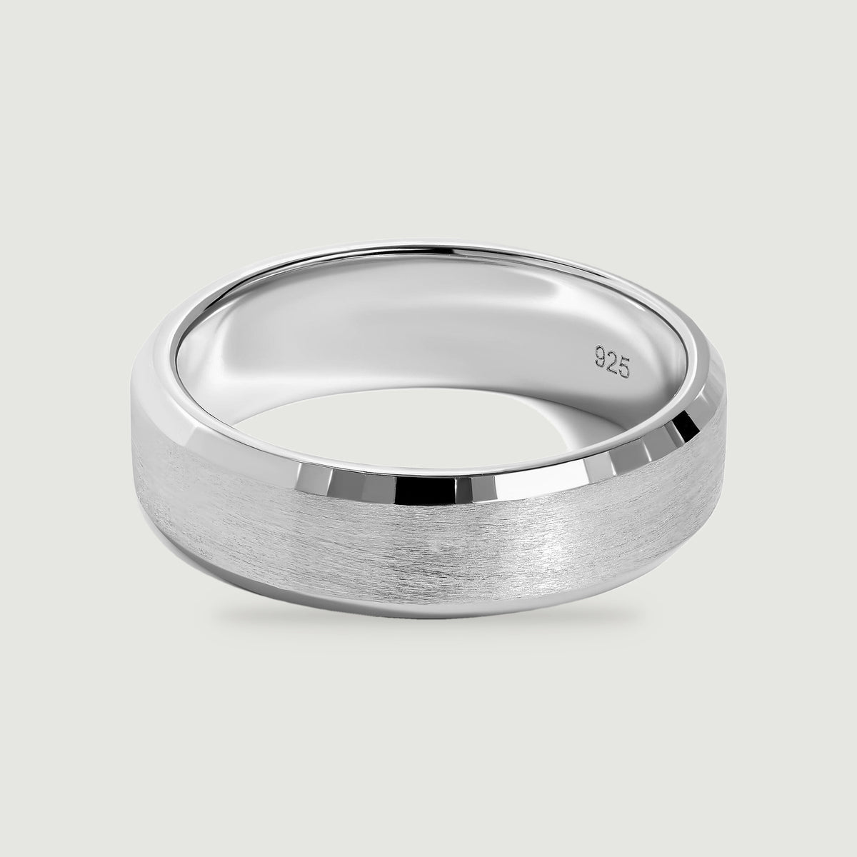 A sterling silver band displays a brushed center and polished beveled edges on a light gray surface.