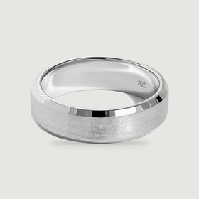 A sterling silver band displays a brushed center and polished beveled edges on a light gray surface.