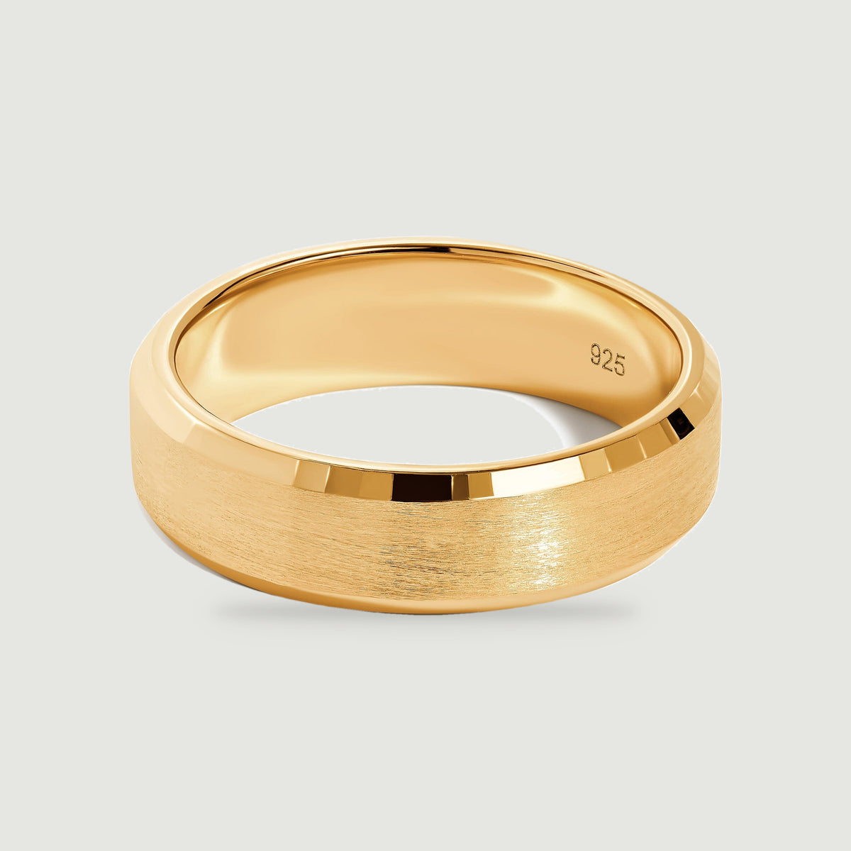 A yellow gold vermeil ring rests at an angle with its smooth interior and satin exterior visible.
