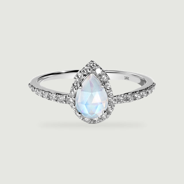 A white gold ring shows a faceted pear-shaped moonstone with a diamond halo and diamond-set shoulders.
