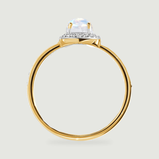 The yellow gold ring is shown from the side with its raised moonstone setting and rounded band visible.