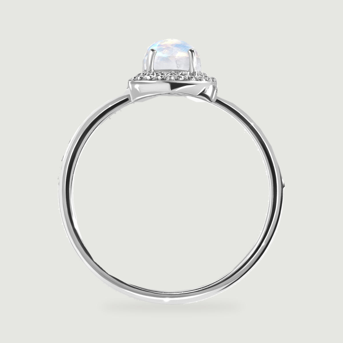 The white gold ring profile reveals the moonstone above its diamond halo and open circular band.