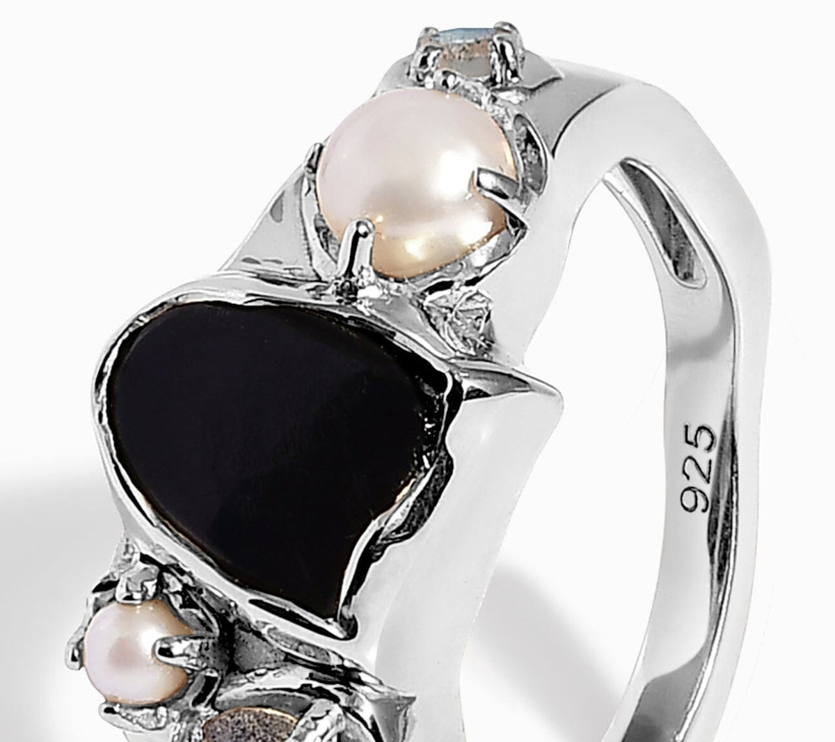 Angled view of the black stone, pearl prongs, and upper silver ring band.