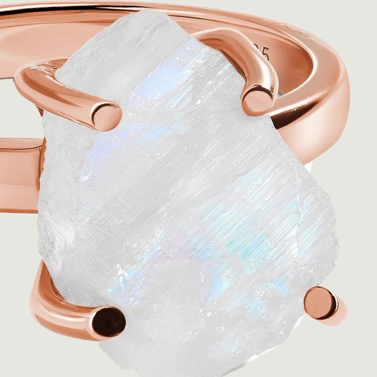 A close view reveals the uneven moonstone surface and rounded rose gold prong tips.