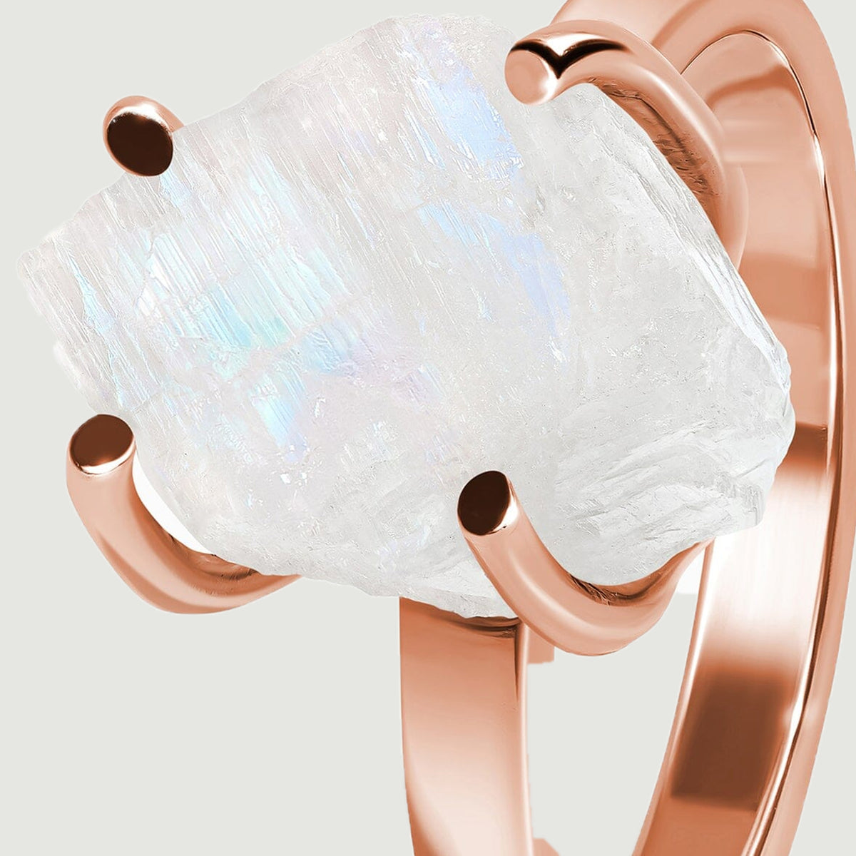 The angled moonstone setting shows its textured edge and the rose gold band beneath it.