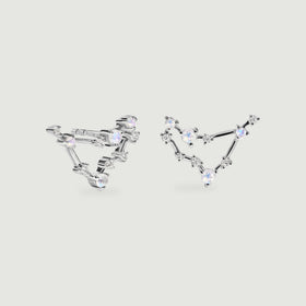 Silver constellation earrings rest side by side with iridescent round stones and polished connecting bars.