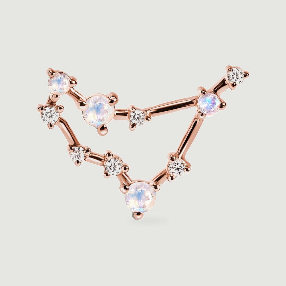 A close view of the rose gold stud shows its angular frame, rounded prongs, and pale stones with blue and pink reflections.