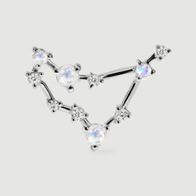 A silver stud is pictured close up, revealing the polished bars and small prong settings around its pale gemstones.