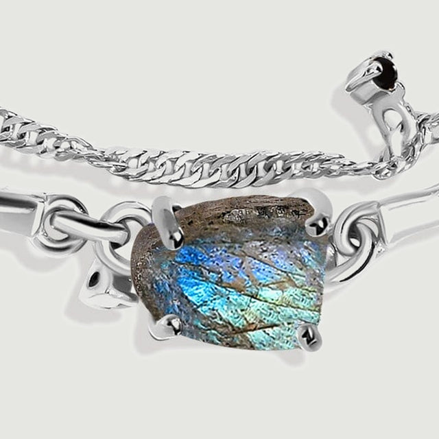 A front close-up reveals the rough blue-grey stone and silver links beside a row of tiny dark bead accents.
