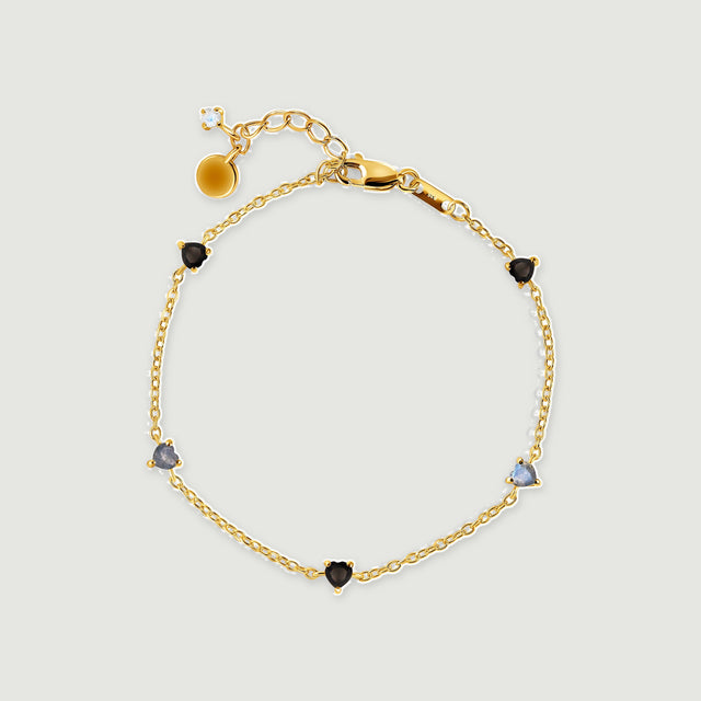 A yellow gold vermeil bracelet is shown with heart shaped stones, a lobster clasp and an extender chain.