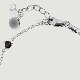 The silver lobster clasp connects to oval extender links beside a small pale blue stone.