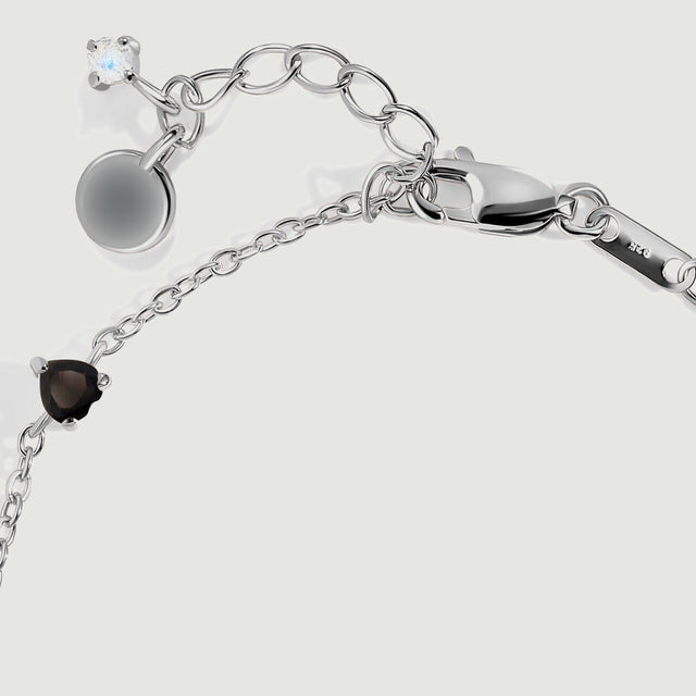 The silver lobster clasp connects to oval extender links beside a small pale blue stone.