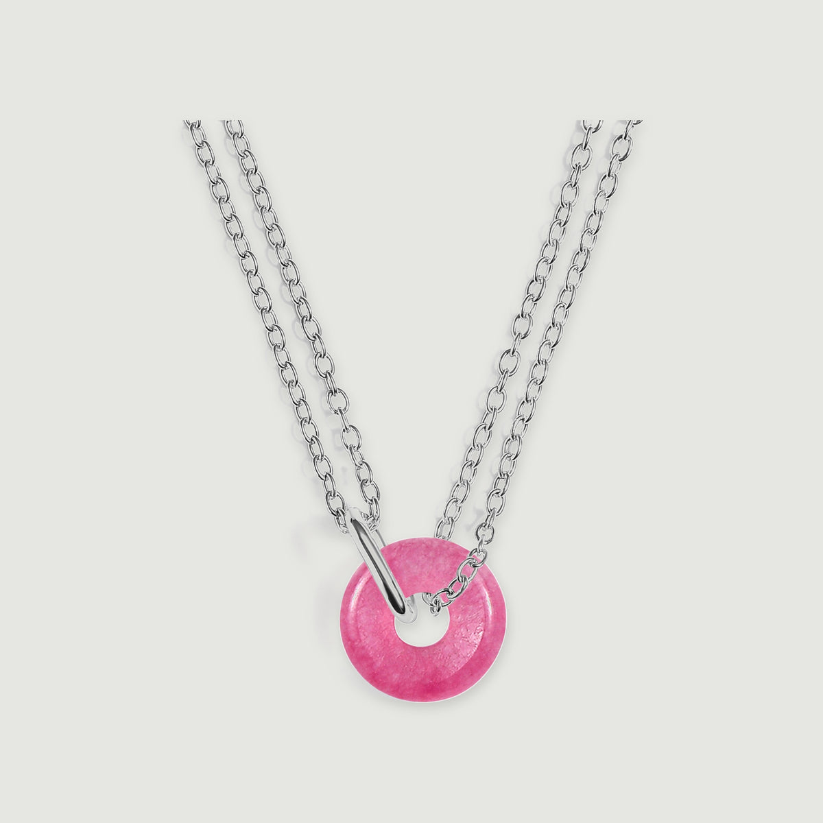 Silver links and a curved silver connector hold a round pink quartz pendant on a pale gray background.