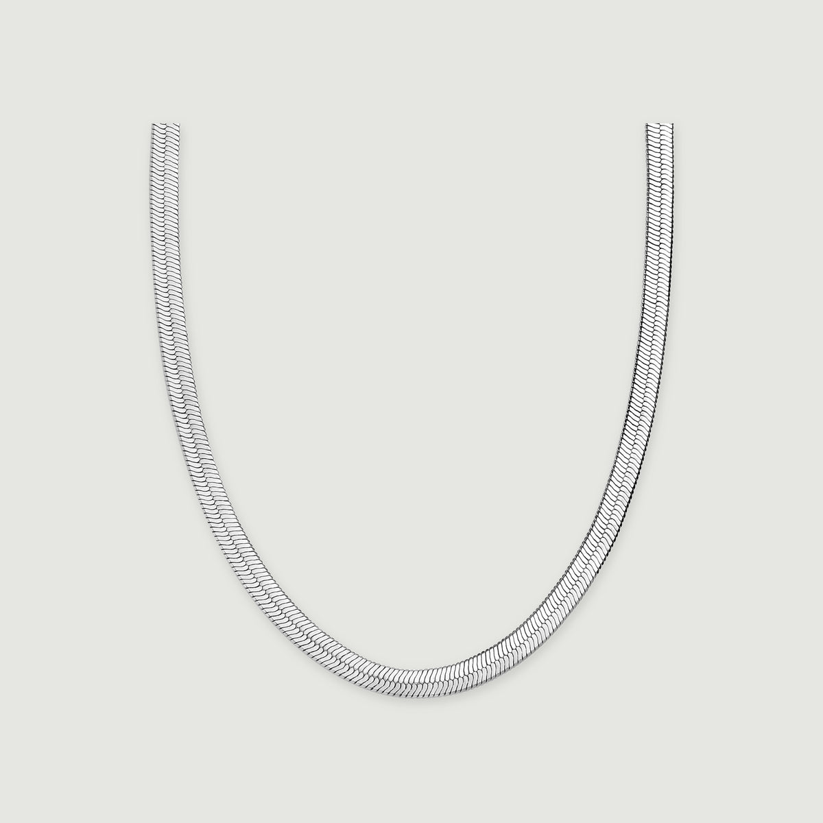 A white rhodium plated herringbone chain forms a broad U shape on a light gray surface.