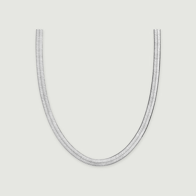 A white rhodium plated herringbone chain forms a broad U shape on a light gray surface.