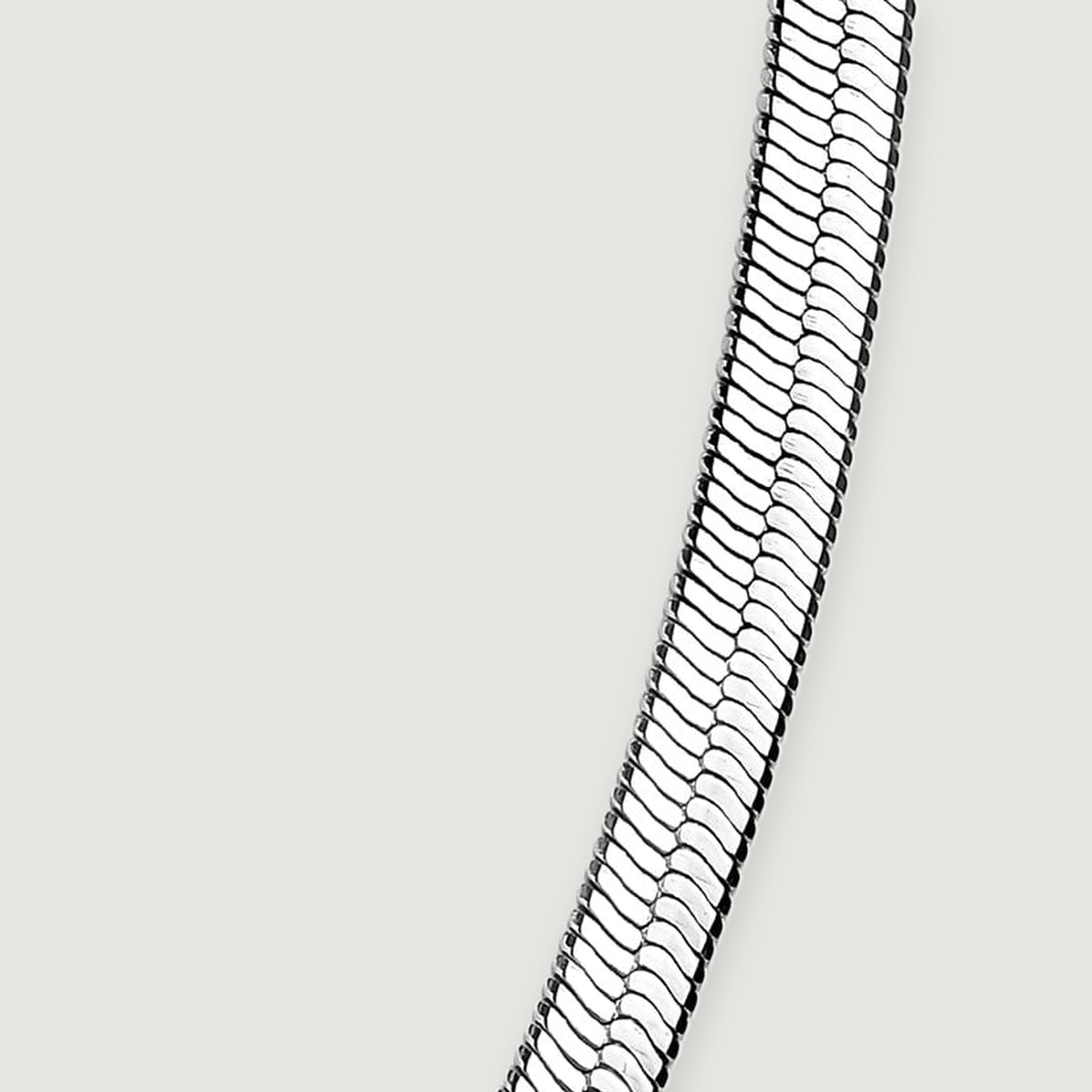 The rising right side of the flat chain shows its slim edge and reflective link pattern.