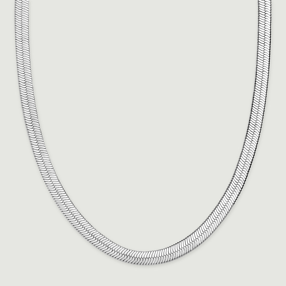 The herringbone chain rests in a wide curve with both sides extending toward the top of the frame.