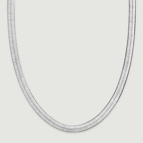 The herringbone chain rests in a wide curve with both sides extending toward the top of the frame.