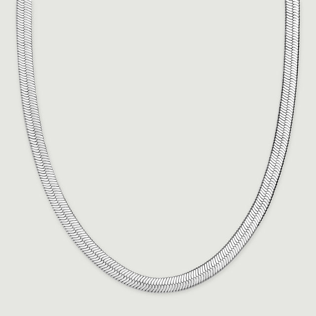 The herringbone chain rests in a wide curve with both sides extending toward the top of the frame.