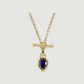 A gold-tone chain and blue pear-shaped pendant are centered on a light gray surface.